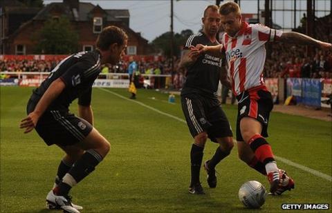 David Noble battles with Raul Meireles as Jordan Henderson looks on