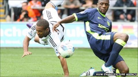 Wayne Routledge takes a tumble against Wigan Athletic