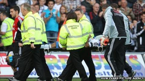 Neil Taylor is taken off on a stretcher