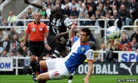 Demba Ba of Newcastle scores his team's opening goal past Scott Dann of Blackburn
