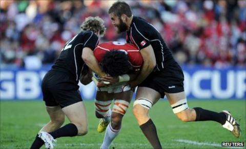 Canada's Conor Trainor (left) and Jebb Sinclair tackle Japan captain Takashi Kikutani