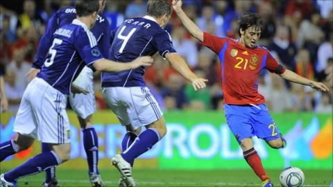 David Silva scores as several Scotland defenders try to block his shot