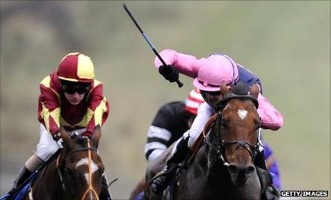 Jockey uses a whip at Brighton races