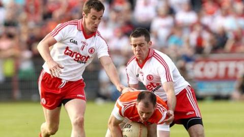 McGuigan and Jordan combine to halt the run of Armagh's Ciaran McKeever in this year's All-Ireland qualifier clash