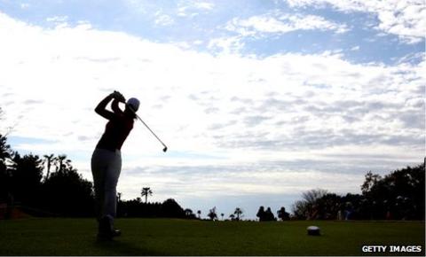 A female golfer tees off