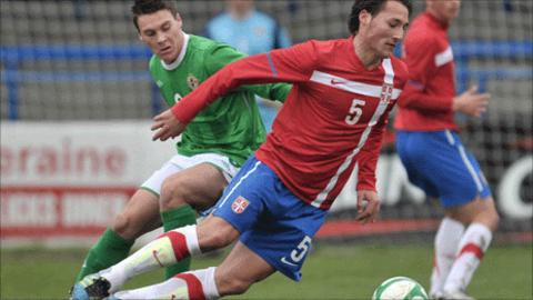 Josh Carson moves in to challenge Serbia's Nemanja Gudelj