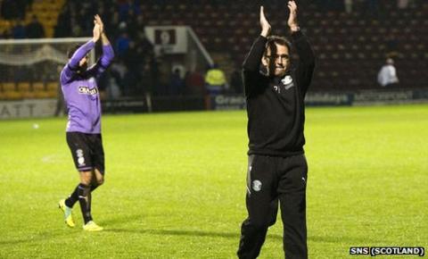 Pat Fenlon salutes the band of travelling Hibs fans at Fir Park