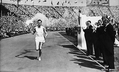British athlete John Mark carries the Olympic torch into Wembley in 1948