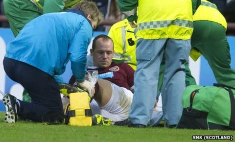 Hearts defender Jamie Hamill receives treatment on his injured ankle