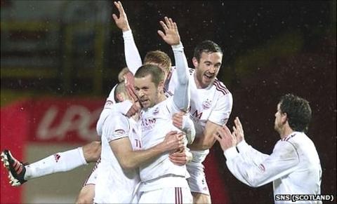 Aberdeen's Kari Arnason is mobbed after scoring the winning goal