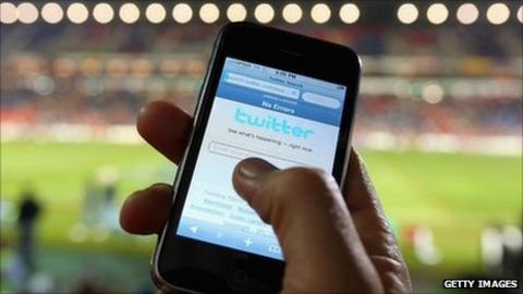 Someone posting on Twitter at a sports stadium