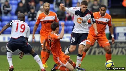 Swansea City's Josh McEachran battles for the ball with Bolton's Joe Riley