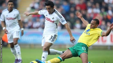 Swansea City's Neil Taylor is tackled by Norwich City's Elliott Bennett