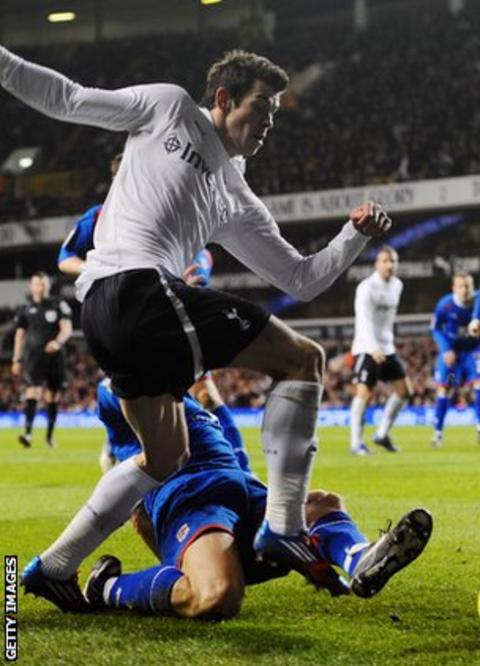 Gareth Bale is challenged by Mark Roberts