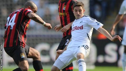 Joe Allen battles for the ball with Manchester City's Nigel De Jong