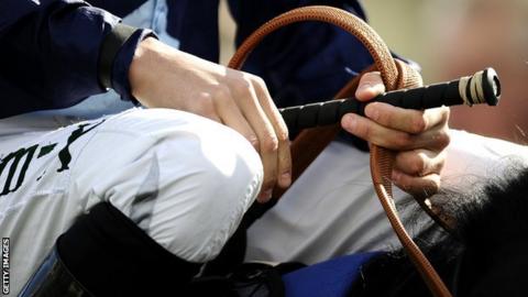 Jockey holding whip