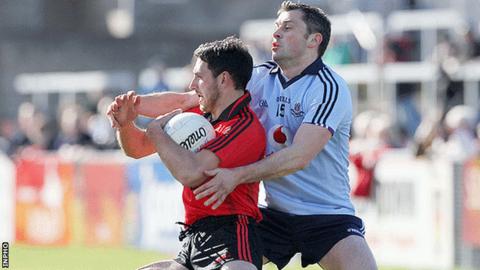 Down's Aiden Branigan is challenged by Alan Brogan of Dublin at Pairc Esler