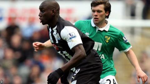 Jonny Howson (right) prepares to challenge Newcastle's Demba Ba