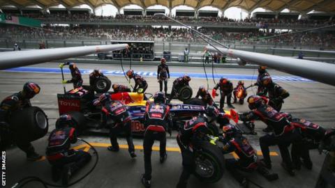 Red Bull mechanics work on Mark Webber's car during the Malaysian Grand Prix