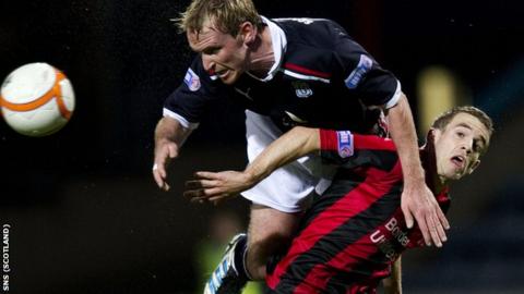 Dundee's Gary Irvine (left) rises above Craig Reid at Dens Park