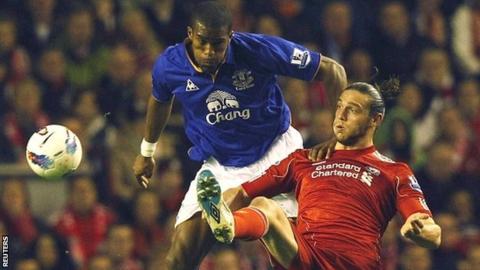 Everton's Sylvain Distin (left) and Liverpool's Andy Carroll (right)