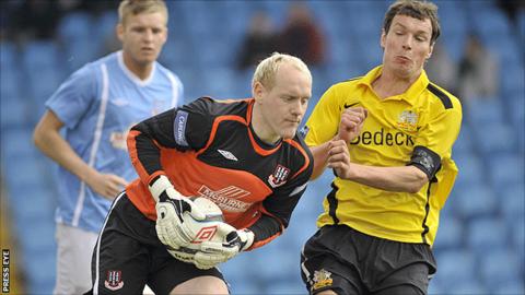 Ballymena goalkeeper Dwayne Nelson gets to the ball before Glenavon opponent Kyle Neill