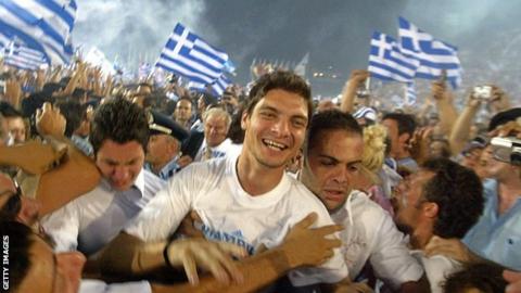 Greece's Angelos Charisteas is mobbed by fans on the team's triumphant return to Athens, 5 July, 2004