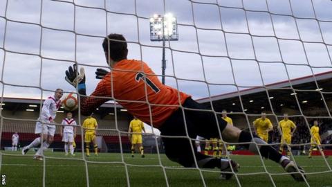 Kevin Cuthbert saves a penalty from Paul Lovering