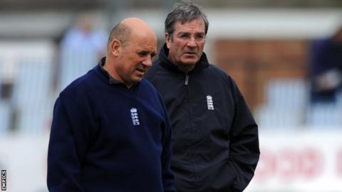 Umpires Mark Benson and Nick Cook carry out an inspection