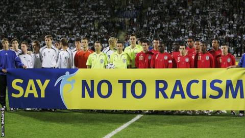 England players hold a 'Say No To Racism' banner in front of the cameras