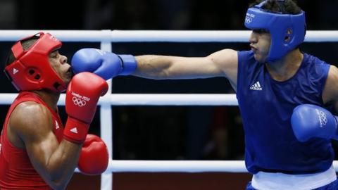 Jose Larduet Gomez (L) of Cuba defends against Ali Mazaheri (R) of Iran
