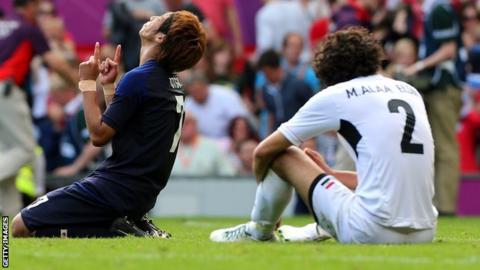 Mahmoud Alaa Eldin sits on the ptich after being knocked out of the Olympics by Japan.