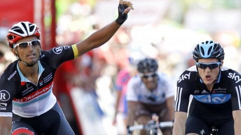 Daniele Bennati (left) raises his arm in celebrtion on stage 18 as Ben Swift (right) misses out