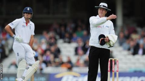 Simon Taufel (r) and England's Alastair Cook (l)