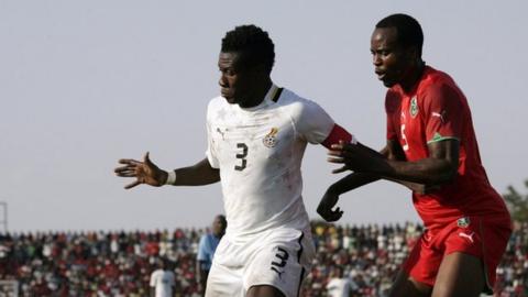 Ghana's Asamoah Gyan (left) battles with Malawi's Foster Namwera