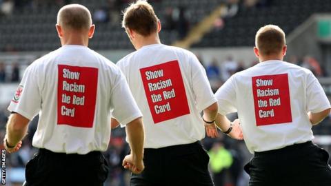 Referee Mike Jones and his assistants warm up with anti racism t-shirts ahead of the Barclays Premier League match between Swansea City and Wigan Athletic at the Liberty Stadium
