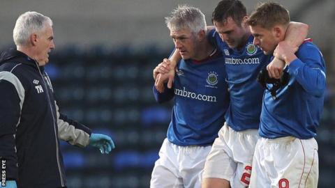 Linfield's Jamie Mulgrew is helped off the pitch by team-mates William Murphy and Peter Thompson