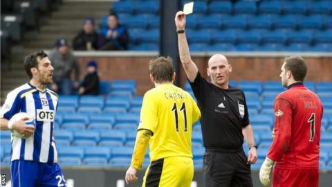 Paul Cairney is booked by Bobby Madden
