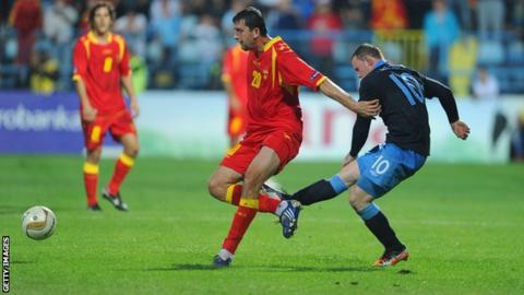 Wayne Rooney of England kicks Miodrag Dzudovic of Montenegro
