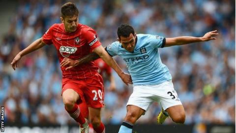 Southampton captain Adam Lallana (left) challenges Manchester City's Carlos Tevez