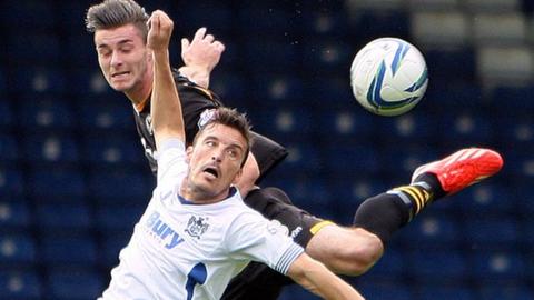 Andrew Hughes of Newport beats Bury's Marco Navas in the air