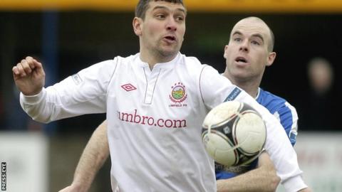 Linfield's Matthew Tipton shields the ball from Dungannon defender Adam McMinn