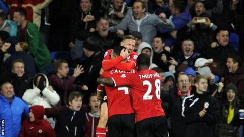 Cardiff match-winner Steven Caulker is mobbed by his team-mates in front of delighted Bluebirds fans