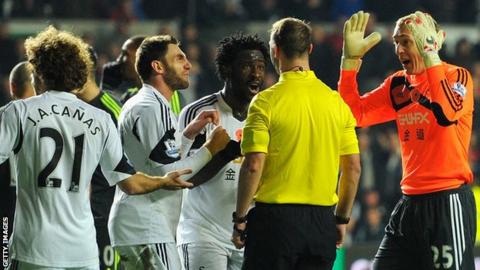 Angel Rangel and other Swansea players remonstrate with referee Robert Madley after he awarded a penalty to Stoke