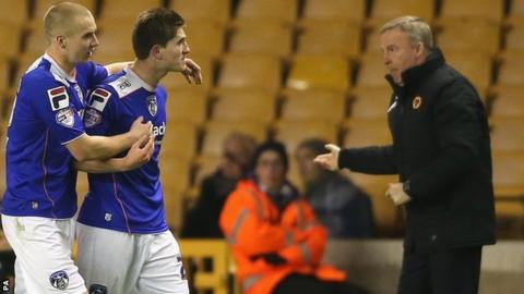 Oldham players celebrate in front of Wolves boss Kenny Jackett