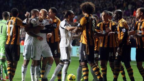 Players clash during Swansea City v Hull City match