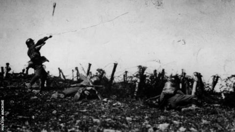 Two Germans drop behind cover, whilst a third hurls a hand grenade towards an Allied trench