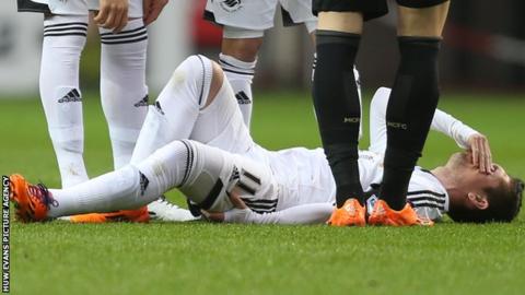 Swansea City's Pablo Hernandez holds his hamstring