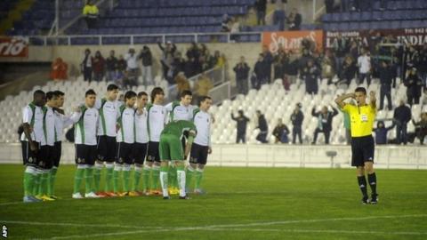 Racing Santander players watch on as the game against Real Sociedad is called off