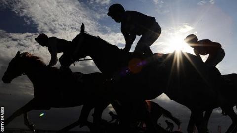 Horses silhouetted at racecourse